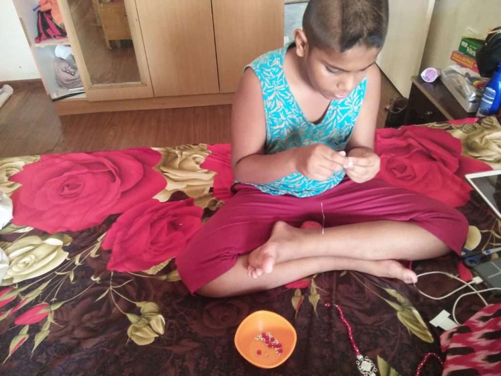 Advaith making a beads necklace