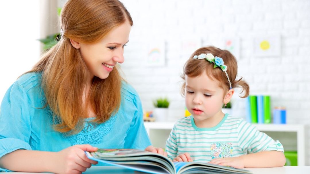 Mother reading wordless books to AAC learners