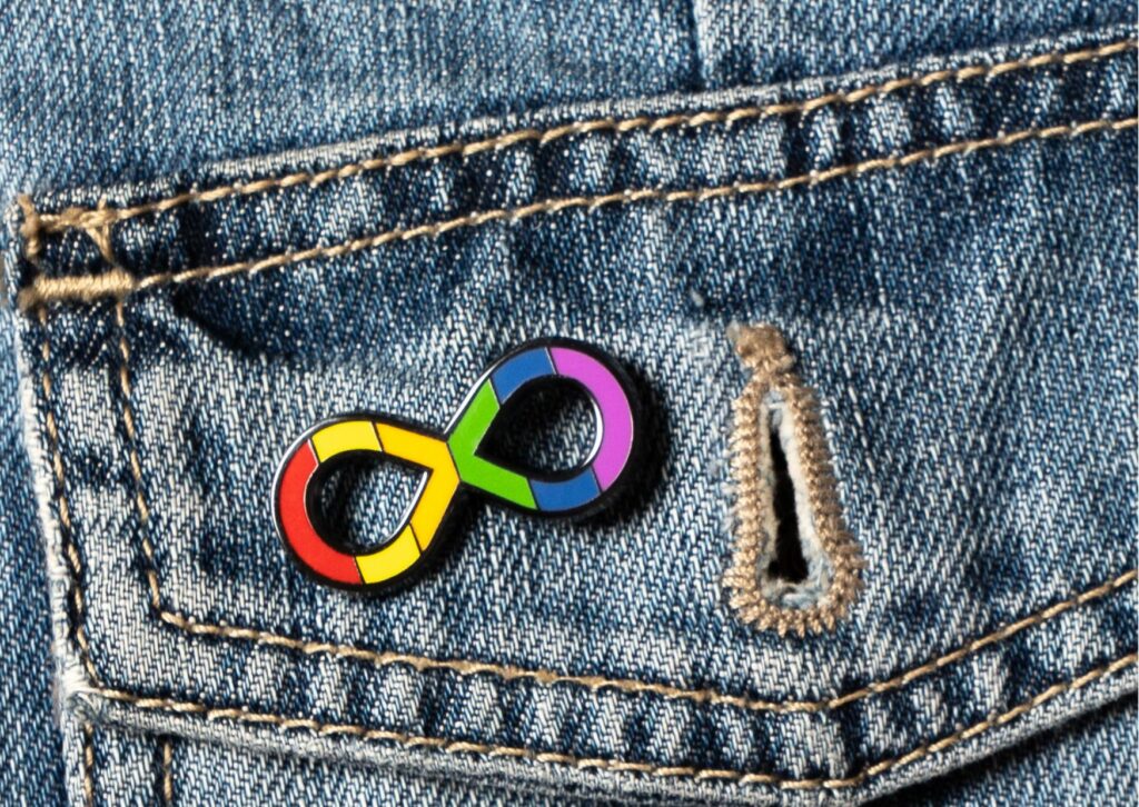 autistic pride symbol rainbow infinity pin on a jean back pocket